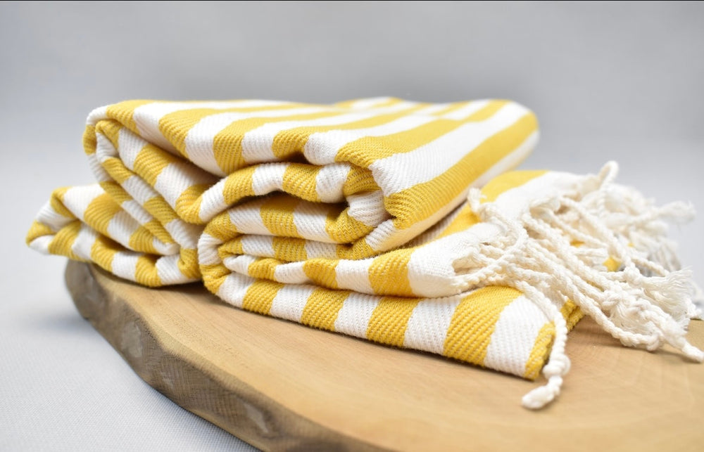 Yellow and white striped 100% organic cotton Turkish Towel on display
