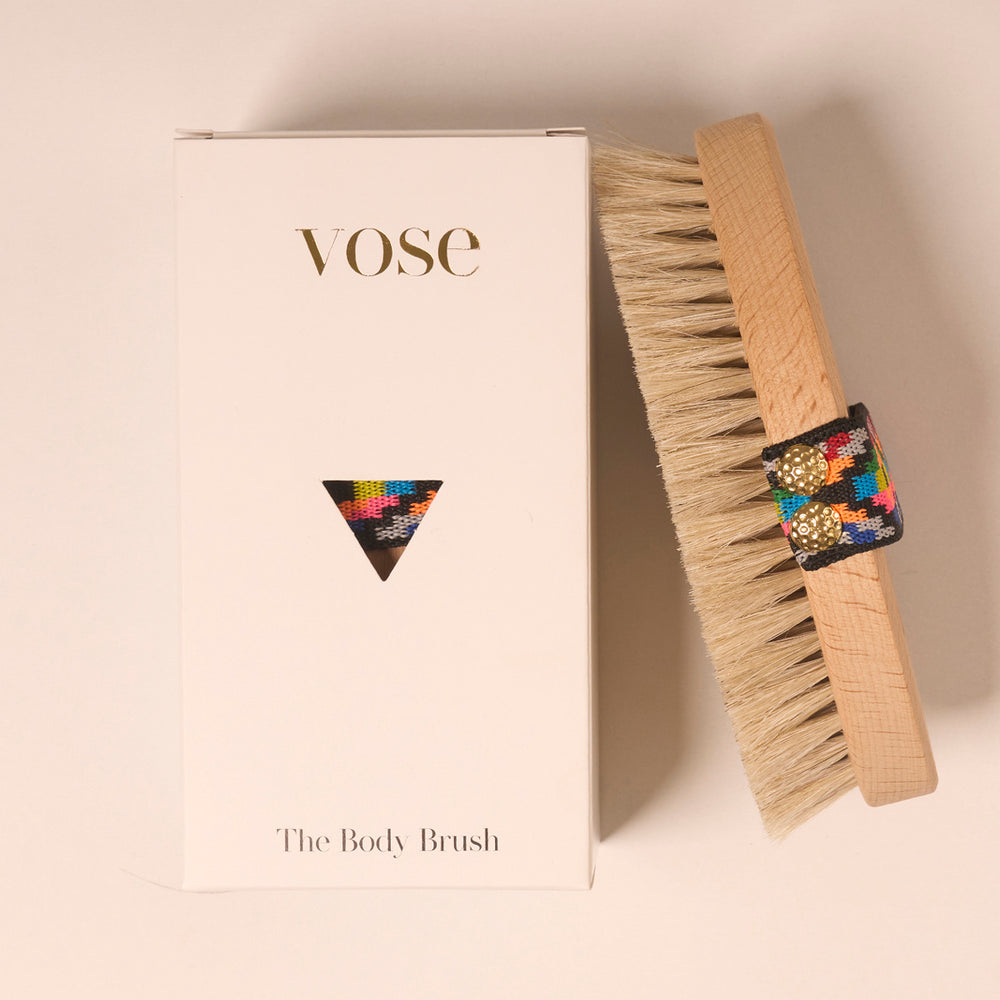 Horse Hair Dry Body Brush with an elastic handle with bright coloured pattern on display with its packaging