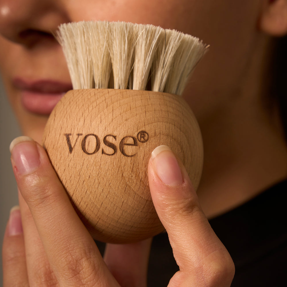 woman holding a round shaped white horse hair face brush