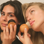 Two women holding dry face brushes with 'Vose' branding against a neutral background
