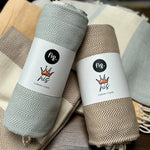 100% organic cotton herringbone patterned Turkish Towel in brown colour on a table with different coloured towels