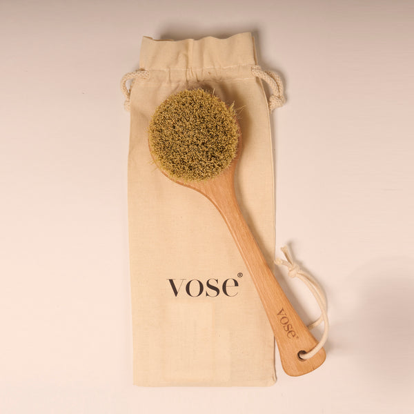 Natural and vegan cactus bristle body brush on display with its cotton pouch