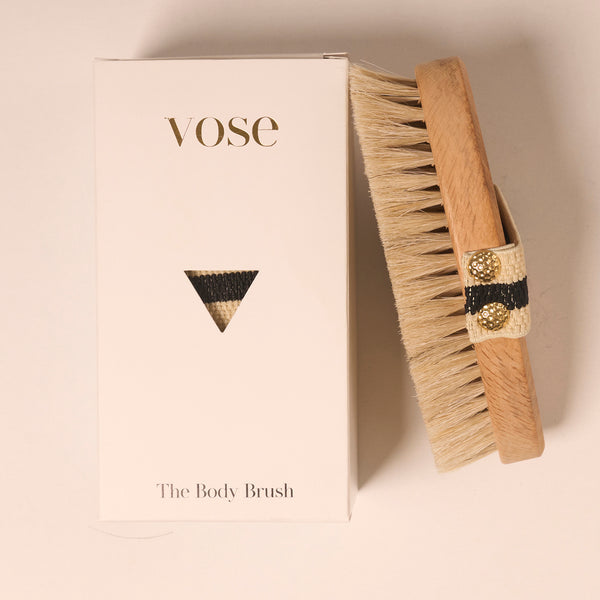 Horse Hair Dry Body Brush with a black and white striped elastic handle on display with its packaging 