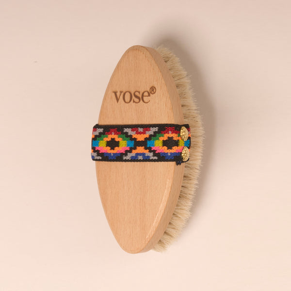 Horse Hair Dry Body Brush with an elastic handle with bright coloured pattern on a pastel background