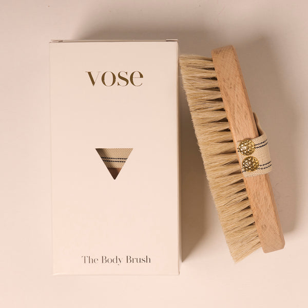 Horse Hair Dry Body Brush with a vanilla coloured elastic handle with thin black stripes on display with its packaging 