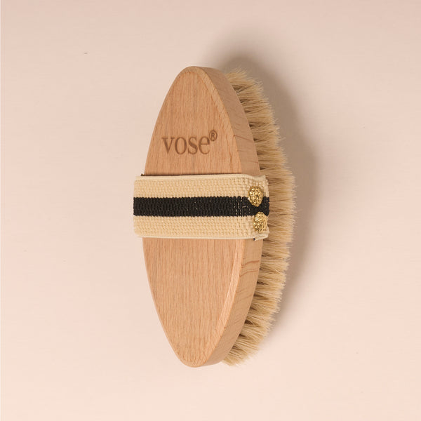 Horse Hair Dry Body Brush with a black and white striped elastic handle on a pastel coloured background