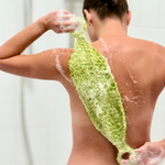 a woman using a loofah or shower mitt to scrub, exfoliate her back