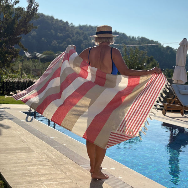 woman holding a turkish towel by the pool